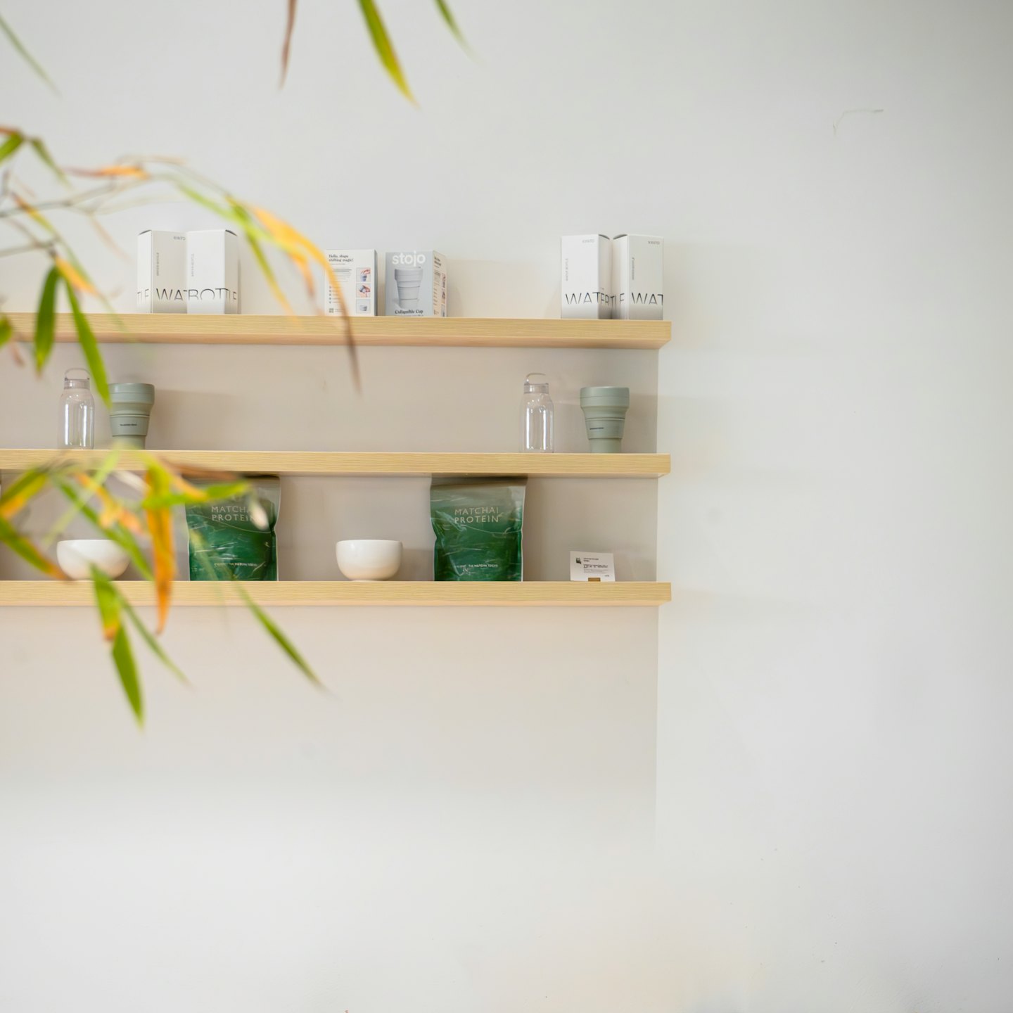 Health and wellness products displayed on light wooden shelves.